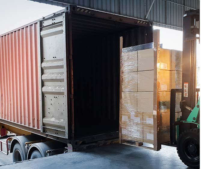 Forklift loading shipment goods pallet into container shipping truck stock image